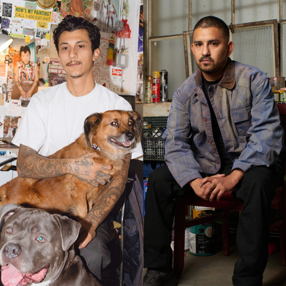 A split portrait of two artists in their workspaces. On the left, Mario Ayala, sits in a studio filled with posters, drawings, and colorful artwork, holding a brown dog on his lap while a gray dog sit in the foreground. On the right, Alfonso Gonzalez Jr. sits on a stool in an industrial studio, wearing a blue paint-marked work jacket, with spray paint cans, stacked milk crates, and art materials behind him.